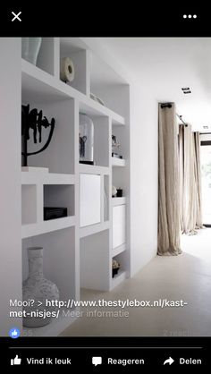 a white room with shelves and vases on the wall in front of doors that lead to an outside patio