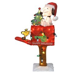 a santa clause is sitting on top of a mailbox decorated with lights and a christmas tree