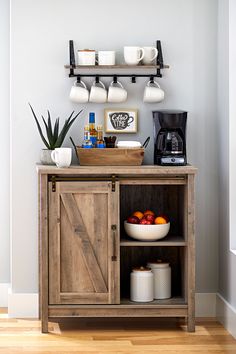 a wooden cabinet with some cups and bowls on it