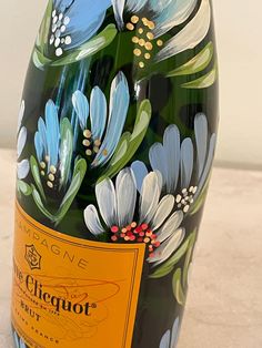 a close up of a bottle of wine with flowers painted on the top and bottom