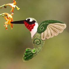 a hummingbird hanging from a branch with flowers in the background