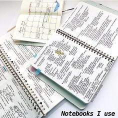 three spiral bound notebooks sitting next to each other on top of a white table