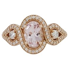 a ring with an oval shaped pink stone surrounded by small white and brown diamonds in the center