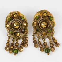 This is part of Chairish’s Costume Jewelry assortment.  French jewelry artist Henry Perichon (aka Henry) designed these stunning Talosel resin clip-on earrings in the 1960s. They feature a brown-beige Talosel resin framing topped with metallic bronze and green glass faceted cabochons and complimented with dangling charms. There is no visible maker's mark, but the style and the French wire clip-back are unmistakable brand signatures. It is in good condition, with minor wear due to age. Measuremen Unique Handmade Formal Clip-on Earrings, Unique Handmade Clip-on Earrings For Formal Occasions, French Jewelry, Jewelry Artist, French Wire, Maker's Mark, Dangle Charms, Clip Earrings, Artistic Jewelry