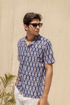 Stay cool and stylish in the Bluebell unisex summer shirt. Featuring a symmetrical tree motif on a blue backdrop, this handblock printed shirt is perfect for adding a touch of fun and comfort to your wardrobe. (Tree-mendous style and breezy vibes guaranteed!) Cabana collar, Relaxed fit 100% Cotton Handmade in India *Please note colors can vary slightly from screen to in person. Small variations add to the beauty of the product. Blue Cotton Camp Shirt For Summer, Blue Cotton Beach Shirt, Indigo Printed Summer Tops, Cotton Block Print Relaxed Fit Top, Spring Cotton Ikat Print Top, Cotton Block Print Tops With Relaxed Fit, Printed Blue Shirt For Summer, Relaxed Fit Printed Blue Shirt, Blue Printed Cotton Camp Shirt