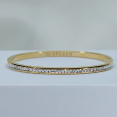 fire up a playful conversation on a sparkling night in our Enchanted Bangle Bracelet. double stack these babies for a luxurious vibe. a timeless staple that will be by your side for every special moment. channel set cz's add just the right amount of sparkle to light up the night. simply add a glass of champagne and you're ready for any celebration. 18kt gold or rhodium pvd over 316L stainless steel water resistant channel set cz's 4mm thick inside diameter is 2.5" pressure click closure sold ind Sparkling Metal Bangle Bracelets, Sparkling Metal Bangle Bracelet, Elegant Adjustable Bangle With Rhinestones, Glamorous Sparkling Bangle Bracelet, Glamorous Sparkling Bangle Bracelets, Dazzling Bling Bracelets As Gift, Dazzling Bling Bracelets For Gifts, Glamorous Bling Bracelets For Gifts, Glamorous Bling Bracelets