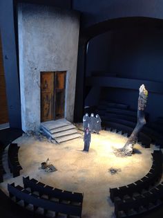 two people standing on stage in front of an open area with steps leading up to the door