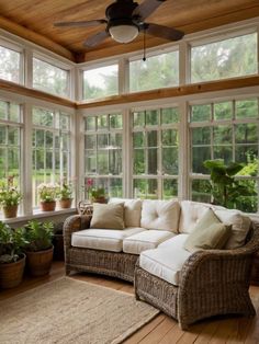 a living room filled with lots of windows next to a wooden floor covered in plants