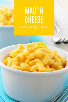 two bowls filled with mac'n cheese on top of a blue table cloth next to silverware