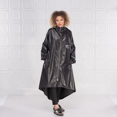 "Black Raincoat Women, Cyberpunk Rain Jacket, Hooded Cape Coat This cyberpunk rain jacket has an asymmetrical design longer on the back and shorter on the front. It has long double side zipper along with two side pockets and long belt to adjust the waistline to your personal needs and fashion style. The elastic finishes on the sleeve and the light fabric make this rain coat a \"must have\" fashion piece for the season. The model in the picture is 168cm. ⅼ 5.6 ft. tall and is wearing size S / col Long Rainy Season Coat For Rainy Weather, Long Raincoat For Winter Streetwear, Winter Streetwear Long Raincoat, Long Fall Raincoat For Streetwear, Fall Streetwear Long Coat Raincoat, Oversized Hooded Raincoat For Rainy Season, Fall Streetwear Long Raincoat, Urban Raincoat With Double-lined Hood For Fall, Techwear Raincoat With Detachable Hood For Fall