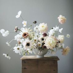 a vase filled with lots of white and pink flowers