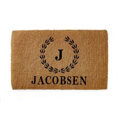 a door mat with the name jacobsen on it and a laurel wreath