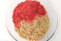 a bowl filled with red, yellow and brown food mix on top of a white table