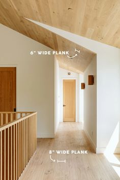 an empty hallway with wood flooring and white walls, showing the width of the room