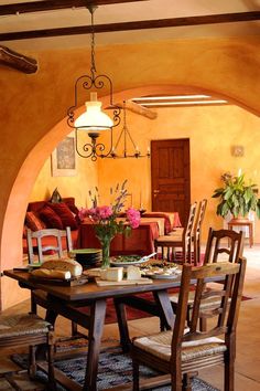 a dining room table with chairs and flowers in vases on the table next to it