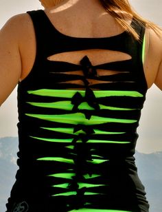 a woman with her back turned to the camera wearing a black and green tank top