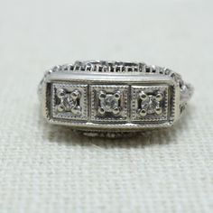 Art Deco Diamond Ring 14k 1920's Estate Diamond Estimated Weight 0.16ct Ring face is 9.15mm across by 16.17mm wide by 6.26mm in height Ring weight 2.8grams Ring size 5.5 can be sized at a low cost Comes with a new ring box Item Number Antique Three Stone Diamond Ring For Formal Occasions, Art Deco Three Stone Diamond White Ring, Diamond White Three Stone Art Deco Ring, Art Deco Diamond Ring Stamped 14k, Formal Art Deco Three-stone Diamond Ring, Vintage White Gold Rectangular Diamond Ring, Vintage White Gold Diamond Ring With Rectangular Shape, Art Deco White Gold Diamond Signet Ring, Art Deco 14k Stamped Diamond Ring