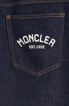 the back pocket of a pair of jeans with an embroidered monogrammed logo on it