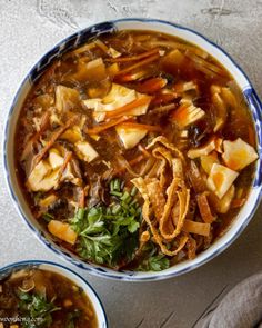 two bowls filled with soup sitting on top of a table