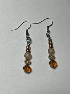 Orange and tan earrings perfect for any occasion! Beige Nickel Free Dangle Earrings, Beige Nickel-free Dangle Earrings, Nickel-free Beige Dangle Earrings, Beige Dangle Jewelry With Ear Wire, Beige Drop Earrings Gift Jewelry, Beige Drop Earrings As Gift, Beige Drop Earrings Jewelry For Gift, Nickel-free Beige Earrings For Gifting, Nickel-free Beige Earrings For Gift