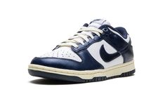 The Women’s Nike Dunk Low PRM "Vintage Navy" is a women’s-exclusive colorway of the retro basketball shoe with a vintage-inspired design.  The “Vintage Navy” honors the Dunk’s storied history as a mid-1980s college basketball team shoe with its aged, vintage look.  The cream rubber midsole mimics the oxidation process rubber undergoes after years of use.  Up top, the shoe features a white leather base with Vintage Navy leather overlays and Swoosh branding that have a slight sheen and textured fi Retro Basketball Shoes, Retro Basketball, Basketball Team, Navy Shoes, Navy Leather, College Basketball, Basketball Teams, Nike Dunk Low, Vintage Inspired Design