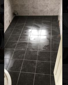 a bathroom with black tile and white walls