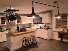 a kitchen with two stools and pots hanging from the ceiling