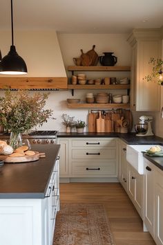 a kitchen filled with lots of white cabinets and counter top space next to a wooden floor