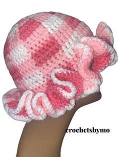 a crocheted pink and white hat on top of a mannequin head