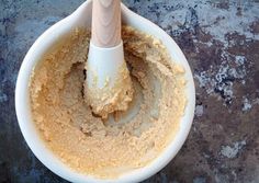 a wooden spoon in a white bowl filled with batter