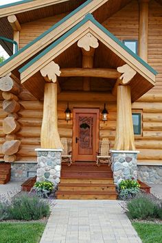 a wooden house with green trim on the front door and steps leading up to it