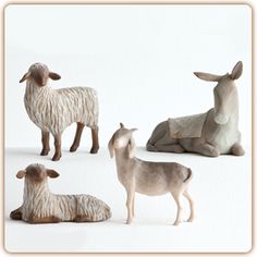 four ceramic sheep and two lambs sitting on the ground, one laying down with its head turned to the side