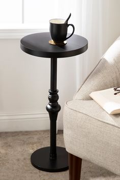 a coffee cup sitting on top of a table next to a chair in a living room