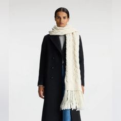 The Emilia Scarf Is Knitted From Luxurious Wool In An Elegant Creamy Off-White Tone. Featuring A Long Silhouette With A Chunky Braided Cable Stitch And Ribbed Detailing, It Exudes Sophistication. Detailed With Fringing, This Scarf Effortlessly Enhances Both Daytime Looks And Cozy Evening Outfits. Versatile And Stylish, It’s Perfect For Adding Warmth And A Polished Finish To Any Wardrobe. Sold Out Style White Knitted Scarf For Fall, White Wool Scarves For Winter, White Wool Scarf For Winter, Chic White Scarves For Fall, Cozy Knitted White Scarves, Cable Scarf, Cable Knit Scarf, Cozy Evening, White Tone