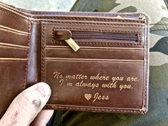 a person is holding a wallet with writing on the front and inside it, which reads no matter where you are i'm always with you