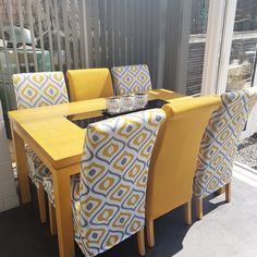 a dining room table with yellow chairs next to a sliding glass door