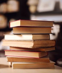 a stack of books sitting on top of a wooden table