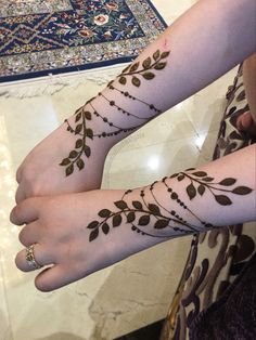 two women with tattoos on their arms and hands, both showing the same tattoo designs