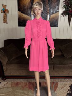 Vintage (1970's) Herman Marcus Dallas~ Size 6 Pink Dress. This is a beautiful pink dress with ruffle design. The dress is in MINT condition with NO tears or stains on the fabric!!  Details: 1.) Breast: 36" inches  2.) Shoulder to shoulder: 13" inches 3.) Sleeve Length: 28"inches 4.) Waist: 22-32" inches (elastic at waist to adjust) 5.) Hip: 40-46" inches 6.) Thigh: 40-46" inches (flare at bottom of dress) 7.) Shoulder to hem: 38" inches 8.) 4 buttons & snap for closure  9.) Fabric doesn't show, Fitted Long Sleeve Pink Ruffle Dress, Pink Long Sleeve Ruffle Dress For Spring, Feminine Vintage Long Sleeve Dress With Ruffles, Feminine Long Sleeve Vintage Dress With Ruffles, Feminine Pink Knee-length Ruffle Dress, Elegant Long Sleeve Pink Ruffle Dress, Elegant Pink Long Sleeve Ruffle Dress, Vintage Knee-length Pink Dress, Vintage Pink Knee-length Dress