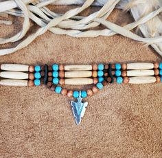 "Native American Indian Style Choker made from Antique Bone Hairpipe beads, turquoise, light brown and brown wood beads. Choker can be ordered with no drop down, 3 feathers, or arrowhead pendant and also 3 rows or 4 rows of beads. Designed and Handmade by me in the United States. Includes tie in back. Approximately 12.5\" in length. Or you can custom order a hairpipe choker in your choice of Genuine Horn or Bone hairpipe beads in the following colors (see other listings: Black Horn Red Horn Gold Native American Choker Necklace Diy, Native Beaded Choker, Bone Choker Native Americans, Cherokee Beaded Necklace, Unique Handmade Arrowhead Necklaces, Arrowheads Jewelry, American Stuff, Arrowhead Pendant, Beads Choker