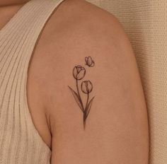 a woman's shoulder with three flowers on it