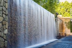 a large waterfall is coming down the side of a building