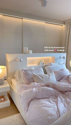 a bed with white sheets and pillows in a bedroom next to a night stand on the floor