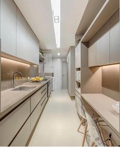 a long narrow kitchen with white counter tops