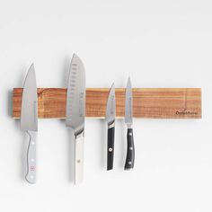 five knives are hanging on a wooden rack