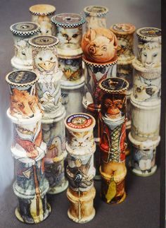 there are many vases that have cats on them in different colors and sizes, all lined up together