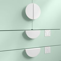 two white round knobs on the side of a green cabinet