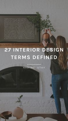 a woman standing in front of a fireplace with the words 27 interior design terms defined