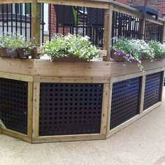 a large wooden planter with flowers in it