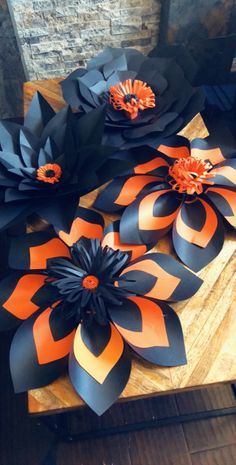 some black and orange paper flowers on a table